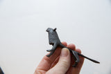 Vintage African lion figure held in hand, highlighting its profile and dark patina.