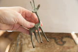 Vintage African gazelle figurine held in hand to demonstrate its scale and patina.