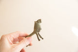 Side profile of the vintage oxidized African lion figurine held in hand.