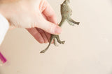 Oxidized metal African lion figure held to show scale and textured surface.