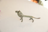 Angled view of the vintage African lion, highlighting its slender form and oxidized patina.