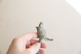 Upward view of the small African lion figurine, highlighting its textured oxidized finish.