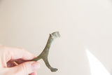 The abstract silhouette and oxidized metal texture of a vintage African lioness figurine.