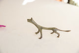 Elongated form of a vintage African cheetah figurine with a mottled oxidized finish.