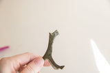 A hand holding the oxidized vintage cheetah collectible to show its size and form.