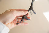 The rough, pitted surface and dark patina on the hind legs of the vintage cheetah figurine.