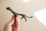 A hand holding the vintage cheetah figure, showing its textured dark patina and scale.