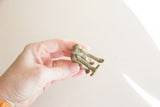 Detail view of the vintage bronze monkey's stylized legs and textured feet.