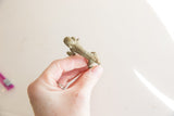 Vintage African bronze monkey held to show its small size and textured details.