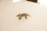 Profile view of a vintage porcupine sculpture showing its rustic oxidized finish.