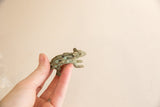 Vintage African porcupine sculpture with oxidized finish held to show scale.