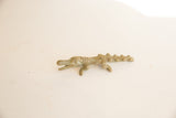 Full profile of a vintage bronze African crocodile with detailed, textured skin.