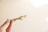 Vintage bronze crocodile figurine showing its side profile and ridged texture.