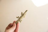 Vintage bronze African crocodile figurine held in hand to show its small scale and texture.