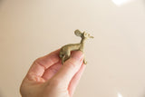 Small African bronze impala figure held to show its scale and vintage patina.