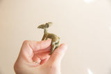 Vintage African bronze impala held in hand, detailing its aged green patina.