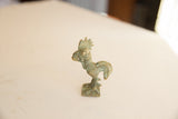 Profile view of a vintage African bronze rooster with a weathered green patina.