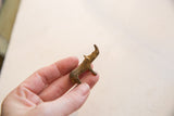 A small vintage African bronze rhino held in hand, showing its compact size and textured patina.