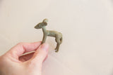 Vintage African impala gold weight held in hand to show its petite scale.