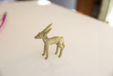 A vintage African impala ram gold weight in profile showing its slender build and aged patina.