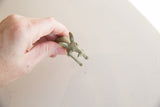 Vintage African impala gold weight held in hand to illustrate its small scale.