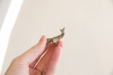 Earthy, weathered patina on the back of a tiny vintage elephant figurine.