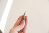 Vintage African elephant collectible held in hand to demonstrate its small size.