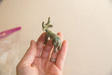 Vintage bronze impala held in hand, showing its scale and aged patina.