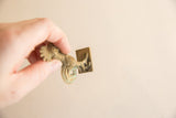 View of the square base and textured underside of a vintage African bronze rooster.