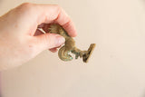 Vintage African bronze rooster held in hand, demonstrating its small scale and detailed texture.