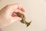 Vintage African bronze rooster figure held in hand to show its petite, collectible size.