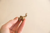 Profile view of a handmade mini elephant showing its rustic texture and small scale.
