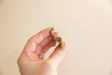Side view of a vintage African mini elephant held to show its small scale and patina.