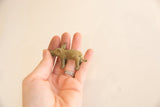 Vintage African pig gold weight held in hand to demonstrate its small collectible size.