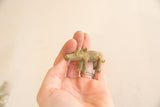 A side profile of the vintage African pig gold weight showing its aged brass patina and small scale.