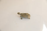 Raised spiral motifs and a green oxidized patina on a vintage African turtle figurine.