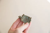 Hollow underside and green oxidized patina of a vintage African turtle figure.