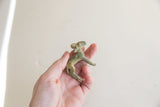 Side view of the vintage African impala ram gold weight held in hand.