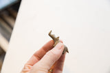 Profile view of the miniature bronze rhino showing its handmade, textured surface.