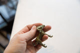 Collector's vintage African impala ram gold weight held, showing aged patina.