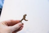 Vintage African mini lion figurine held in hand to demonstrate its petite size.