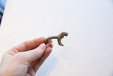 Vintage African mini lion held in hand, showing its textured, aged metal surface.