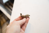 A small vintage African elephant figurine with an aged patina held in hand.