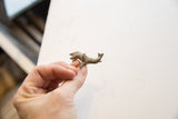 Vintage African mini elephant with a weathered finish held in hand to show its small size.
