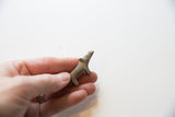 A hand holding the tiny vintage African hippo to show its scale.