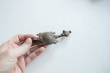 Vintage African turtle pendant held in hand to show its scale and textured patina.