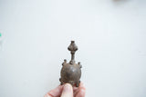 Vintage African turtle pendant with a textured spiral shell held in hand to show scale.