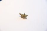 Angled view of the vintage oxidized turtle pendant showing its spiral shell patterns.