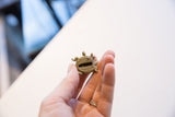 Side view of the vintage turtle pendant held to show its scale and textured shell.