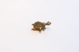 Side view of the vintage African turtle pendant, showing the oxidized metal and cage-like shell.